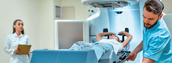 Ärztin, Röntgentechniker und Patientin bei der Vorbereitung im CT-Raum